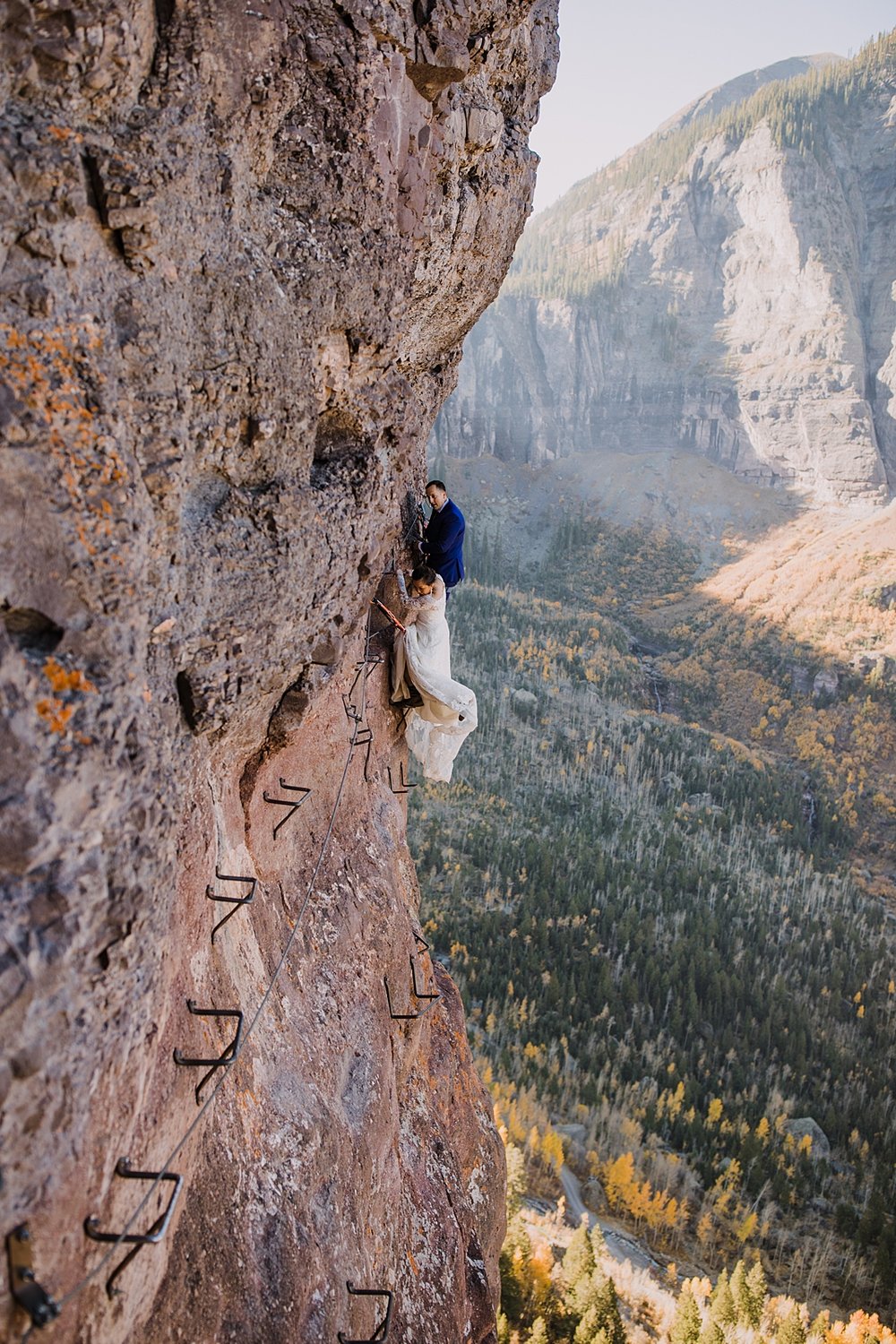 bride and groom eloping on a cliff edge, eloping on the via ferrata's main event, rocky mountain range climbing, hiking the telluride via ferrata trail, high alpine mountaineering elopement