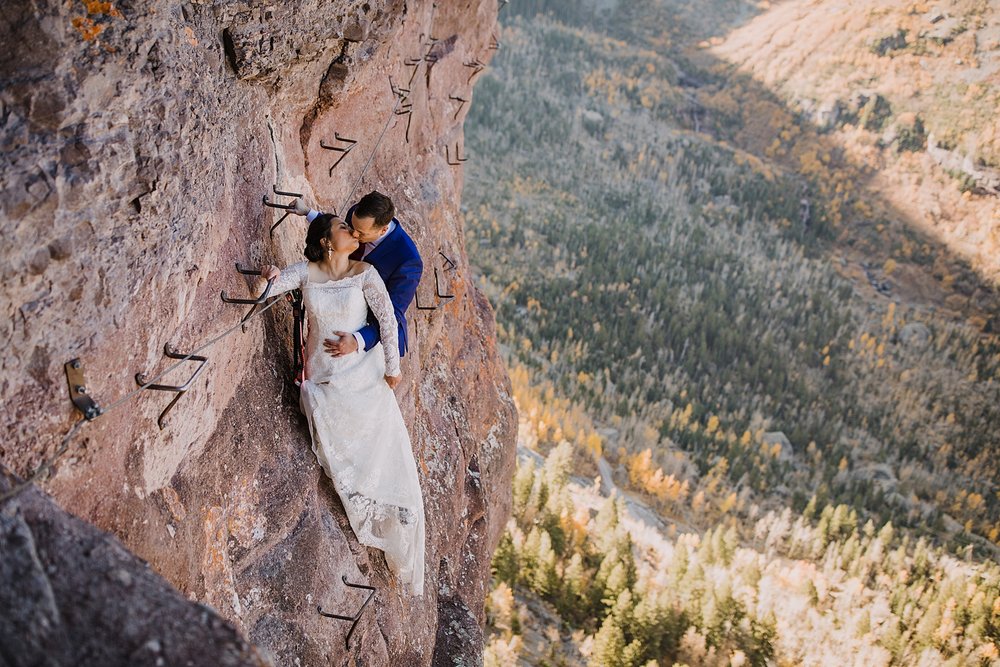 bride and groom kissing on edge of cliff, high alpine elopement, southern colorado hiking elopement, climbing couple, climbing in a wedding dress, hiking in a wedding dress, hiking in a tux