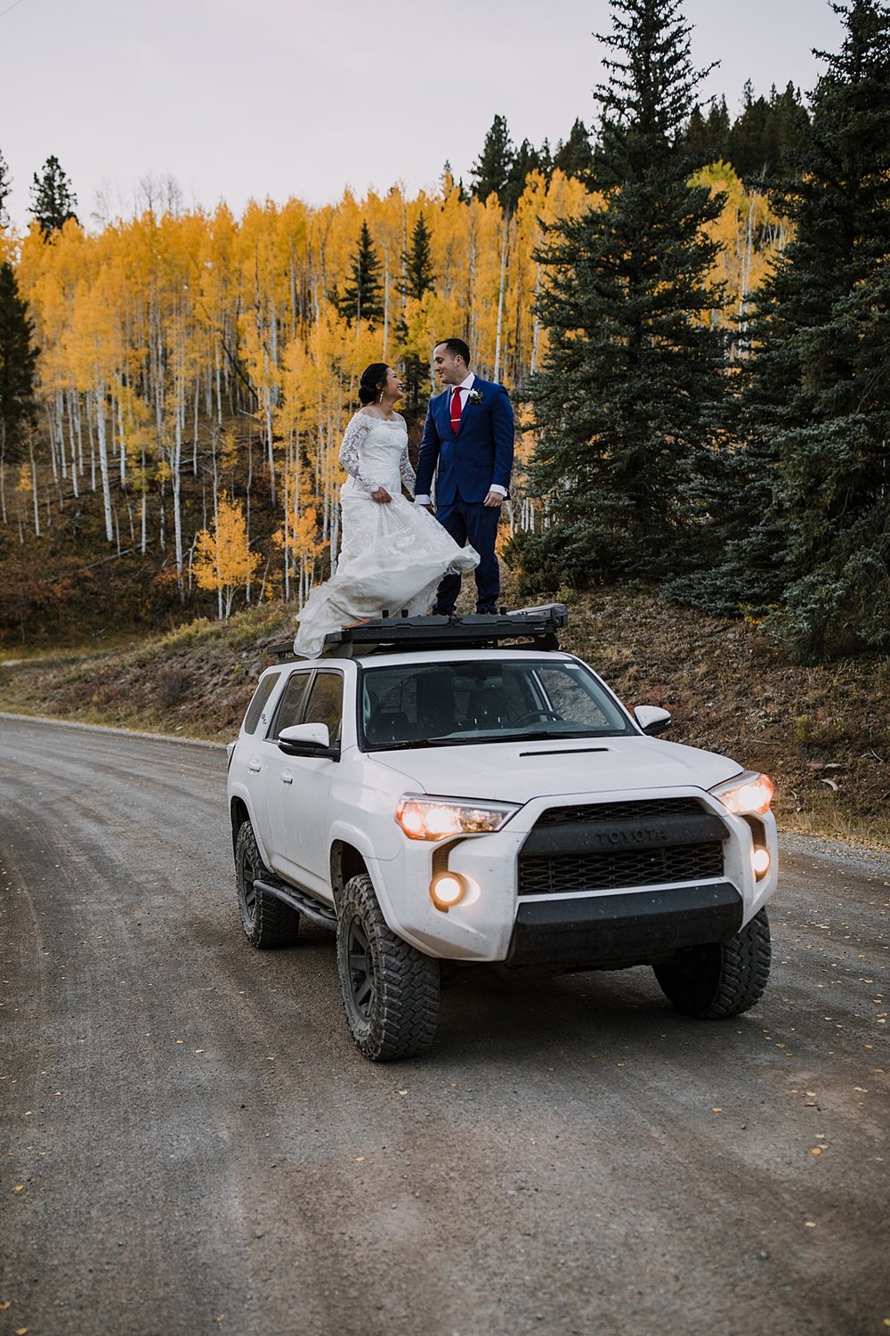 bride and groom dancing on car, bride and groom standing on toyota 4runner, offroad elopement with a toyota 4runner, 4x4 elopement, mountain pass road elopement, 4wd adventurous mountain elopement