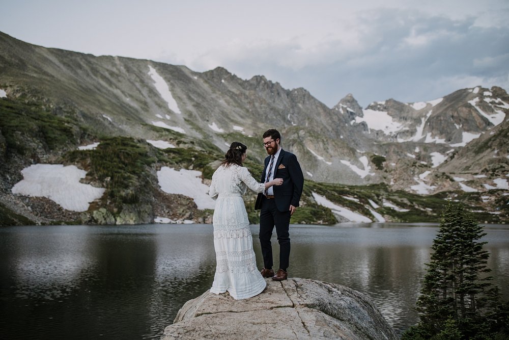 bride and groom elopement first look, bride and groom standing on lake shore, indian peaks wilderness, elopement at lake isabelle, backcountry trekking elopement, glacier valley elopement