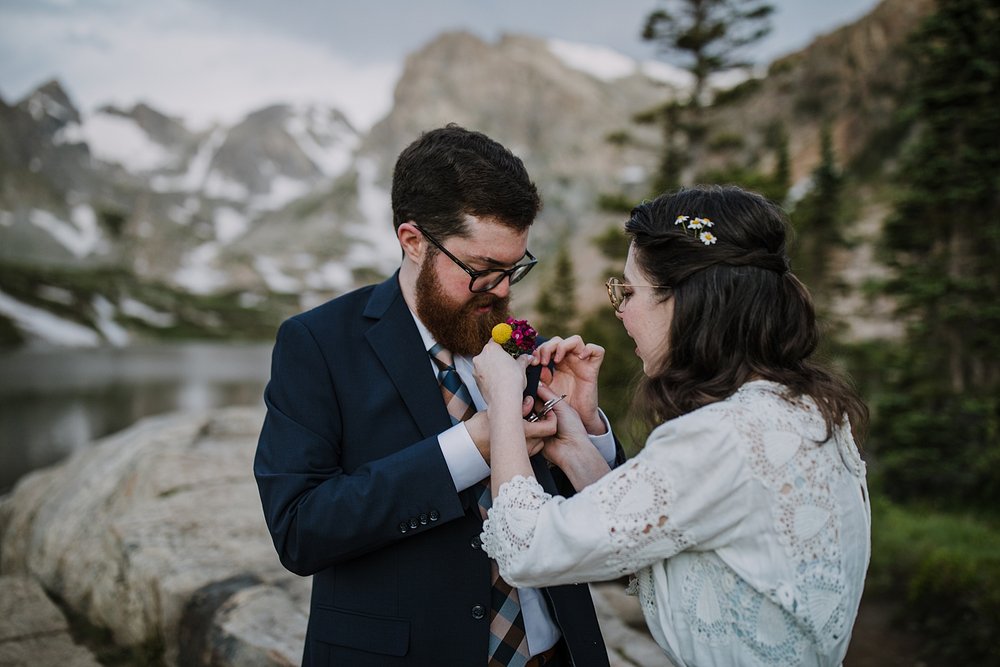 groom putting on boutonniere, bigfoot multi tool, grooms elopement attire, ward colorado elopement, estes park elopement, nederland elopement, lakeside elopement