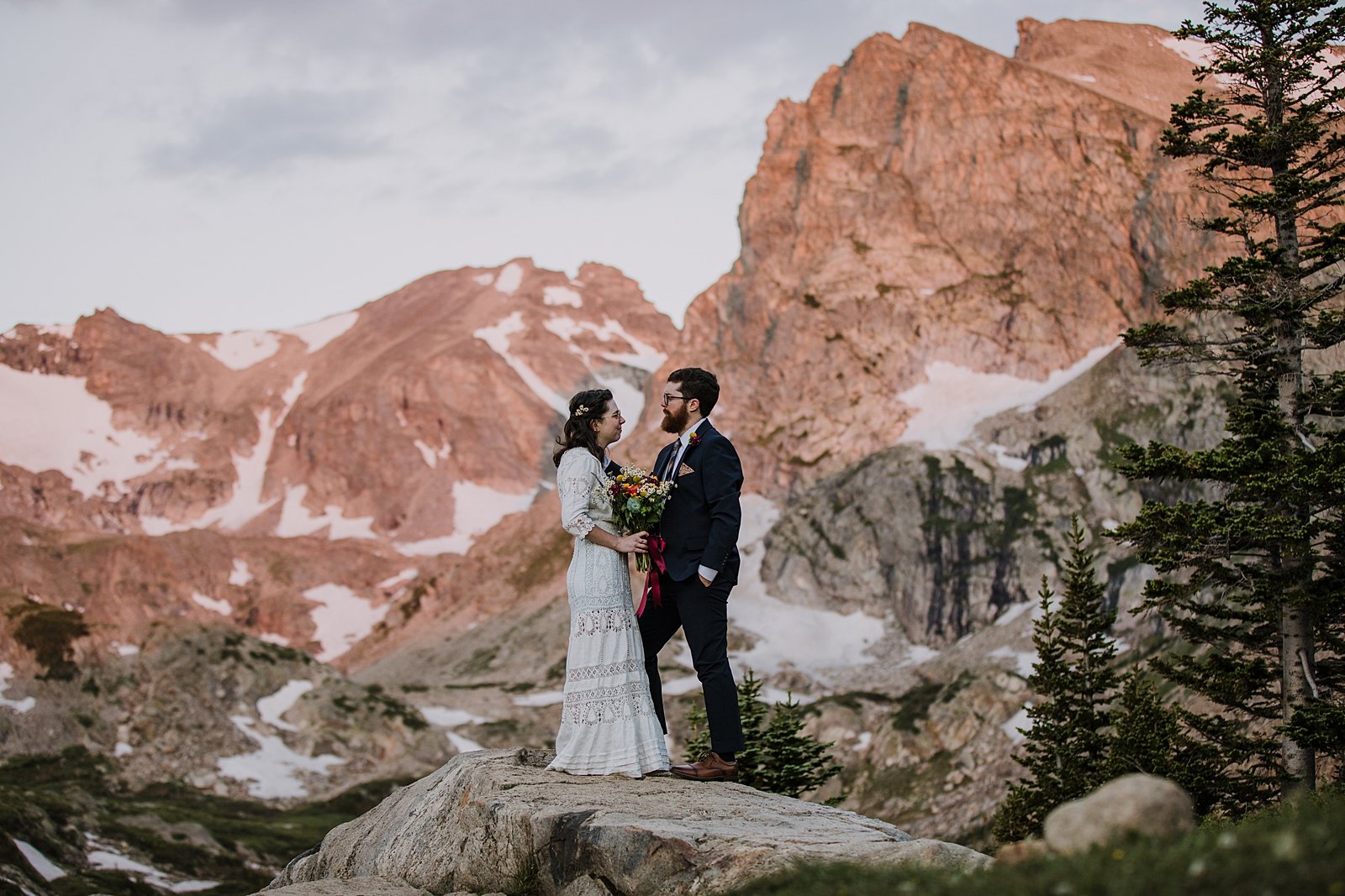 couple watching sunrise, sunrise on shoshoni peak, alpine glow in the indian peaks wilderness, alpine lake elopement ceremony, colorado front range sunrise