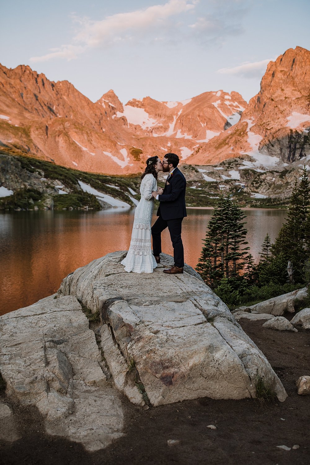 groom kissing his bride, colorado mountain alpenglow, sunrise in the indian peaks wilderness, intimate elopement ceremony, rocky mountain sunrise, pink mountains