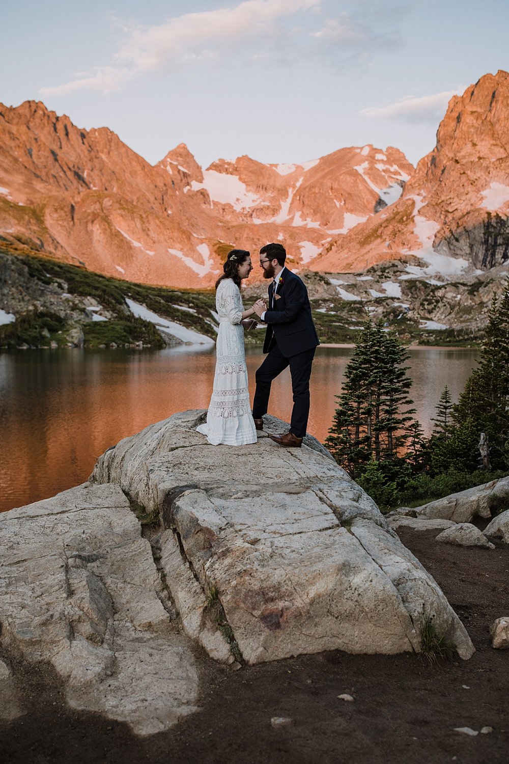 bride and groom sunrise vows, colorado mountain alpenglow, sunrise in the indian peaks wilderness, intimate elopement ceremony, rocky mountain sunrise, pink mountains
