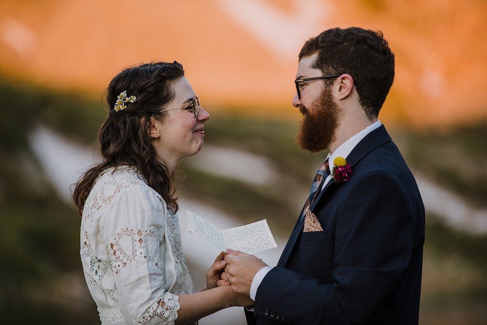 groom sharing his wedding vows, alpenglow reflection on alpine lake, self solemnizing in colorado, self solemnizing ceremony, snow laiden peaks, pine forest elopement