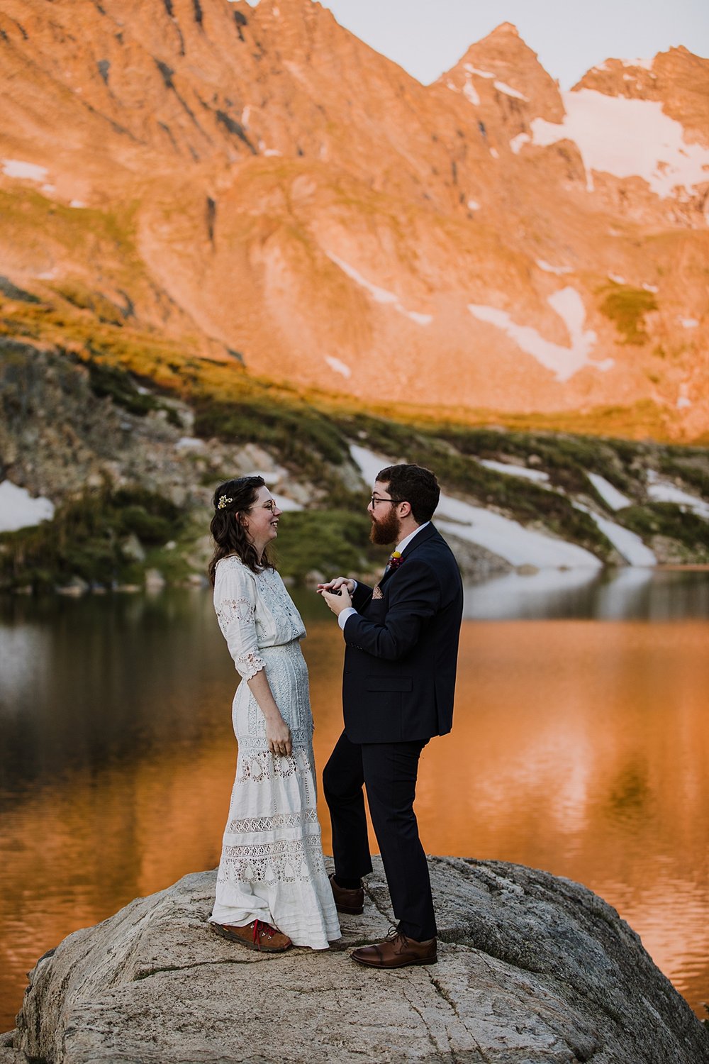 bride and groom exchange rings, high alpine lake elopement, mountain peak elopement, spring snow runoff, snow laiden peaks, national forest elopement
