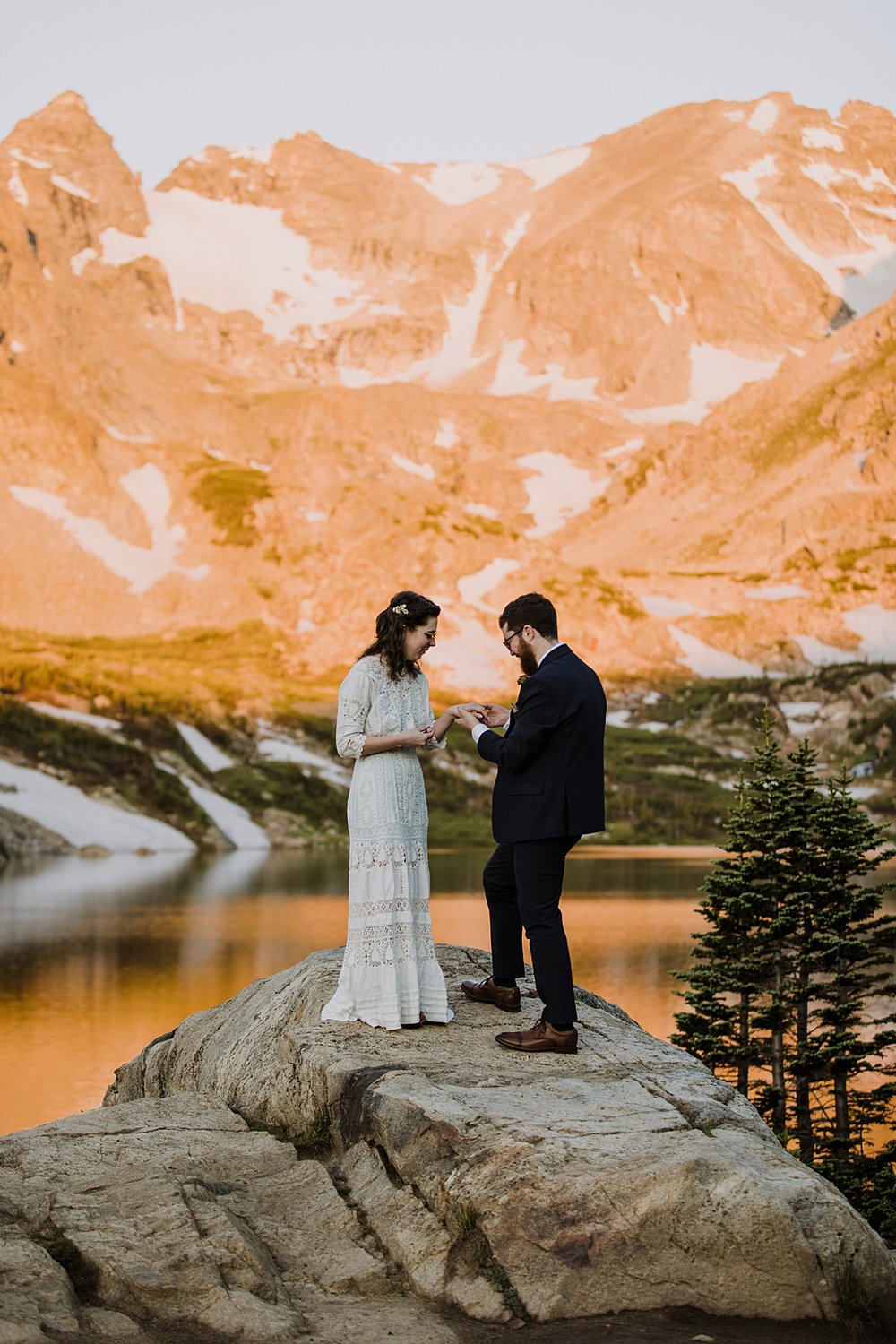 bride and groom exchange rings, high alpine lake elopement, mountain peak elopement, spring snow runoff, snow laiden peaks, national forest elopement