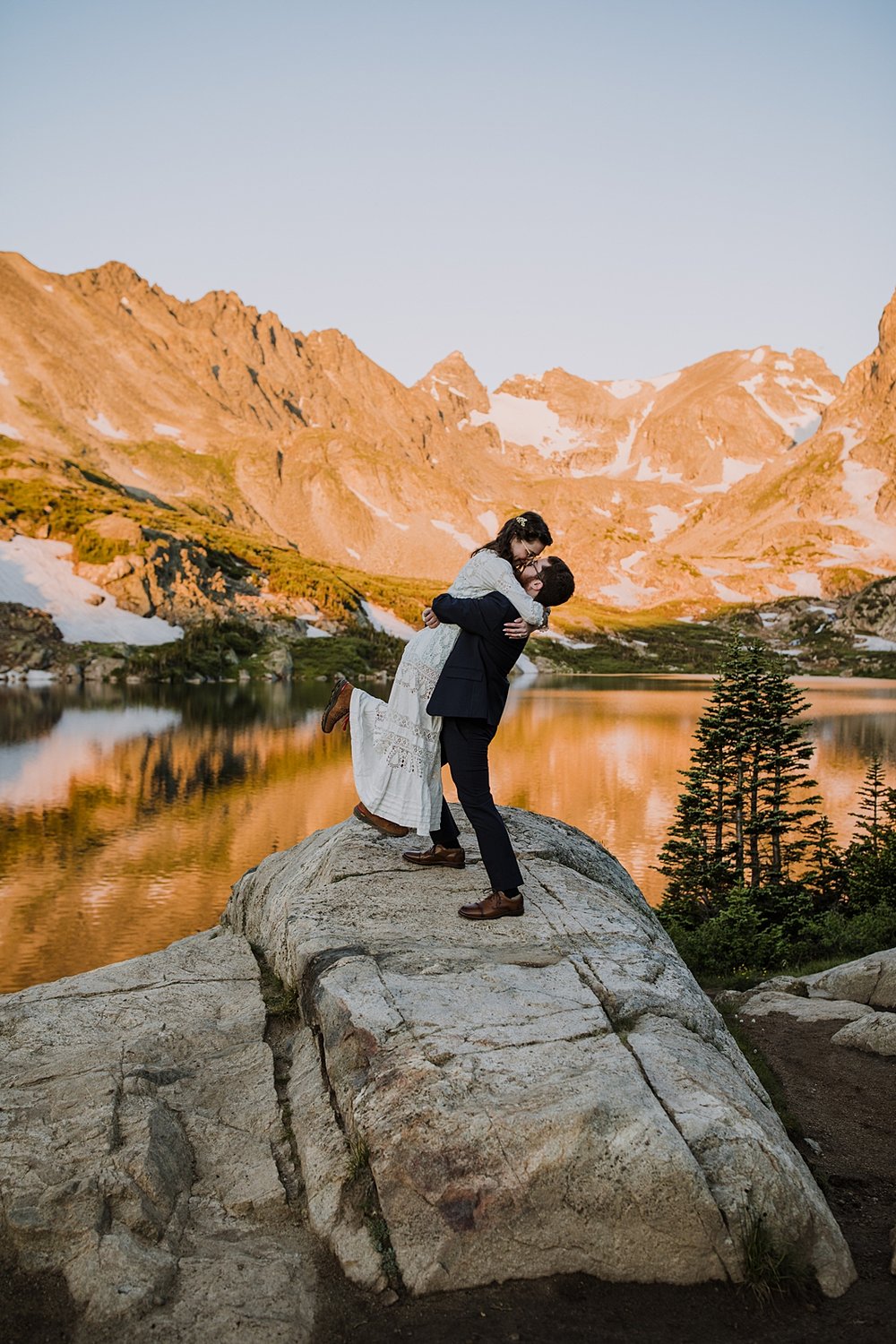 bride jumping in grooms arms, groom swinging bride around, antique edwardian wedding dress, century old wedding dress, alpine lake adventure elopement, sealing the deal, orange mountains