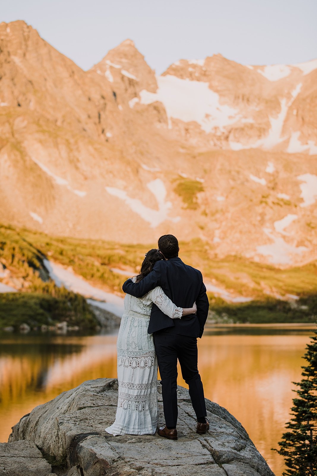 bride and groom watching the sunrise, couple cuddling, hand crotched lace wedding dress, 100 year old wedding dress, sunrise hiking in the rocky mountains, mitchell lake parking