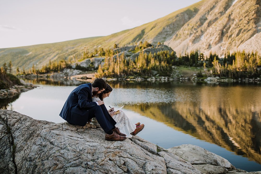 bride and groom signing marriage license on lake shore, couple signing marriage license, colorado marriage license, glacier elopement, glacier run off, sunrise on glacier valley, mountain granite