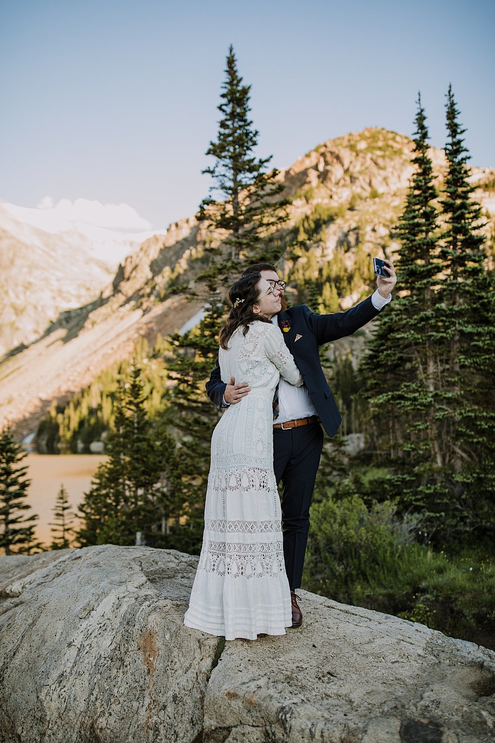 wedding couple taking a selfie, eloping above tree line, post vow celebration, honeymoon roadtrip, western states roadtrip, budget wedding dress, budget elopement, high alpine trail hiking