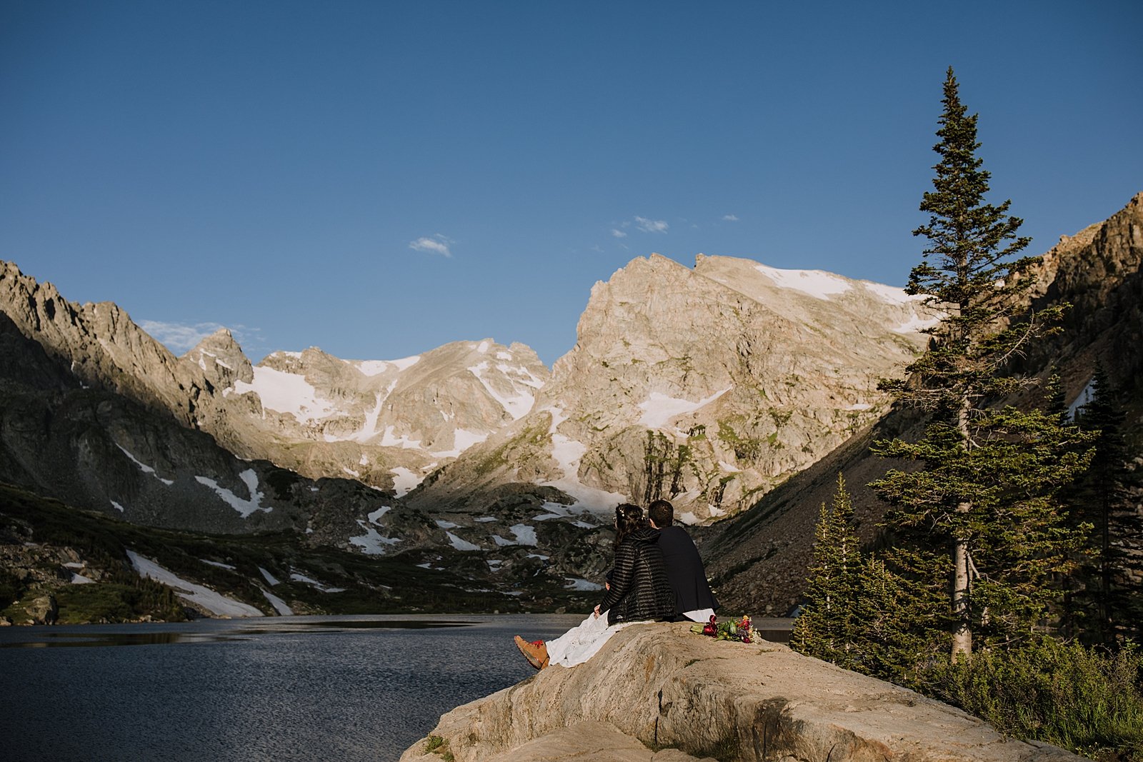 couple sitting on rock overlooking alpine lake, lake isabelle view, hiking lake isabelle glacier trail, pawnee pass trail, shoshoni peak