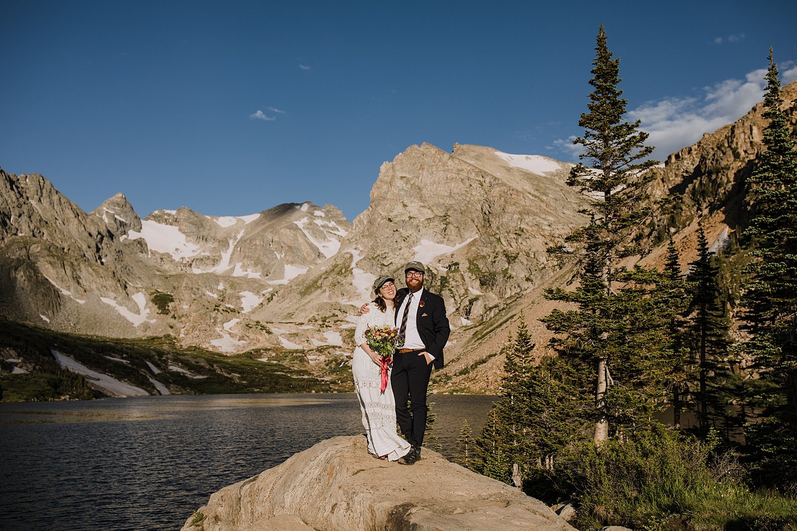 couple standing on rock overlooking alpine lake, lake isabelle view, hiking lake isabelle glacier trail, pawnee pass trail, shoshoni peak