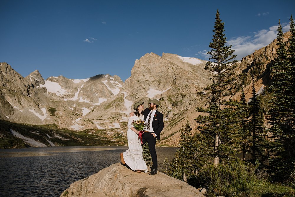 couple kissing by alpine lake, lake isabelle view, hiking lake isabelle glacier trail, pawnee pass trail, shoshoni peak