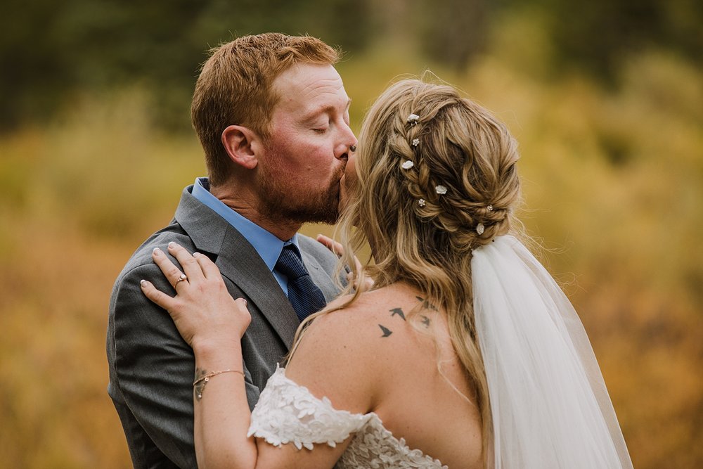 groom kissing bride, breckenridge forest wedding, colorado wooded wedding, breckenridge nordic center hiking trails, breckenridge fall hiking elopement, breckenridge wedding photographer