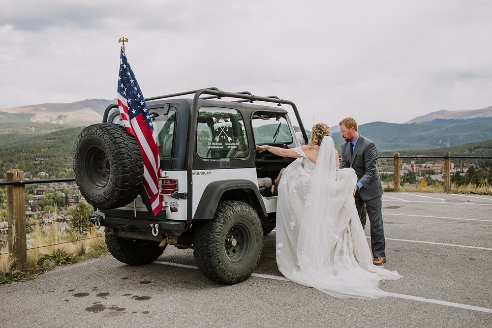 bride and groom kigroom helping bride get into jeep, wedding dress in a jeep, colorado jeep wedding, breckenridge jeep wedding, breckenridge overlook, drive baldy mountain colorado jeep trail 