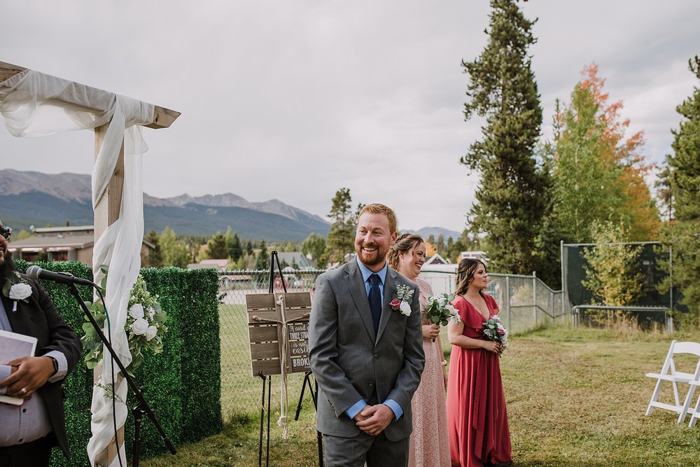 groom awaiting bride, bride walking down the aisle, breckenridge colorado fall wedding, carter park pavilion fall wedding, intimate wedding reception at carter park pavilion in breckenridge