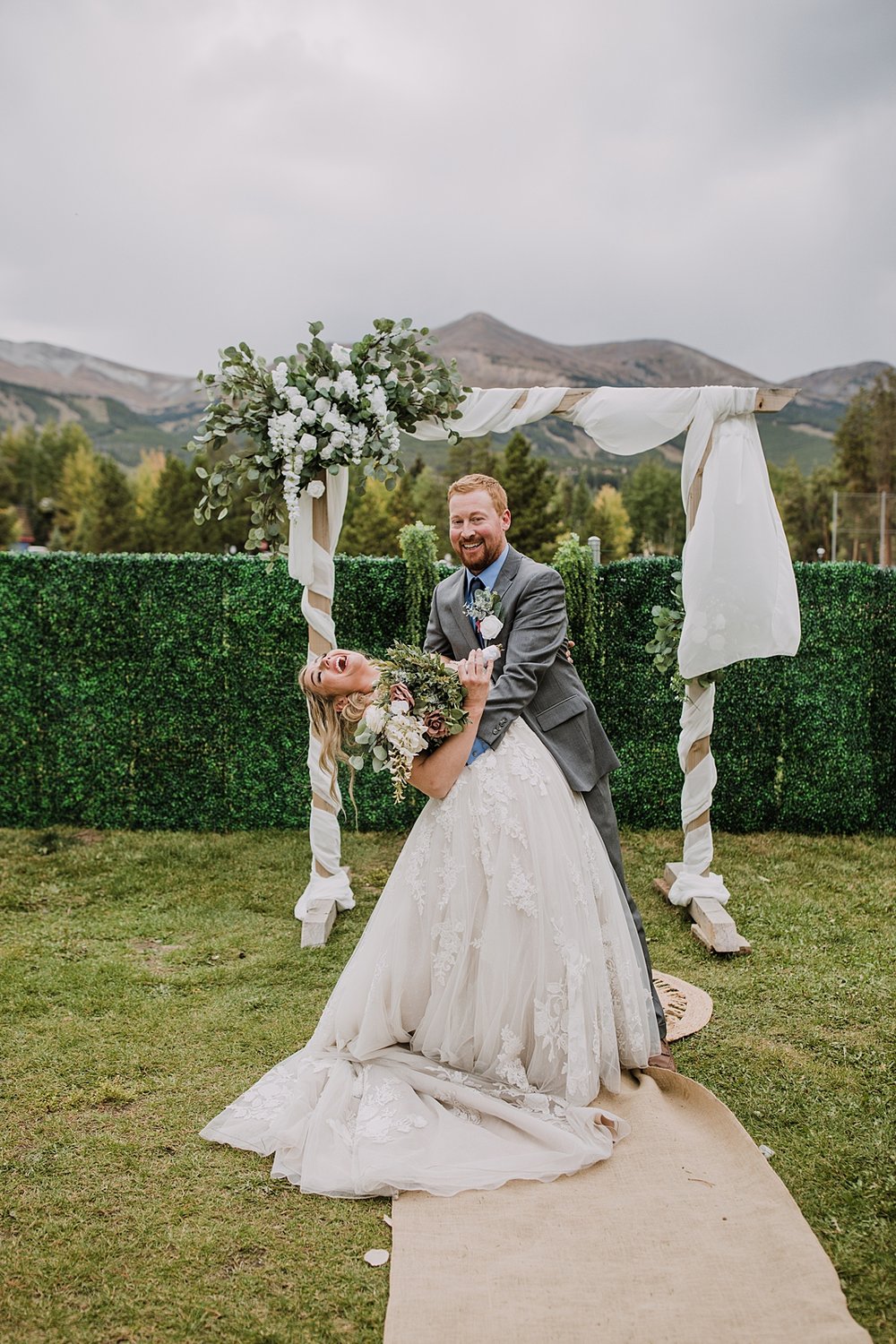 bride and groom kissing in front of ceremony arch, wedding ceremony at carter park pavilion, vow ceremony in breckenridge colorado, reception space in breckenridge colorado