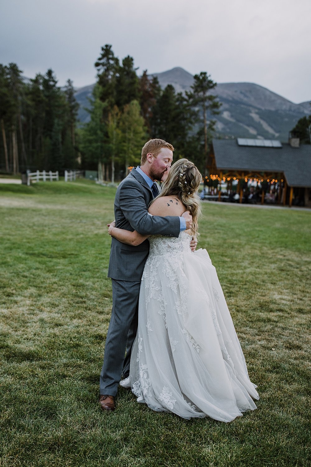 bride and groom kissing on sledding hill, bride and groom sneaking away for sunset, peak 8 wedding reception, boreas pass wedding, breckenridge mountain wedding reception