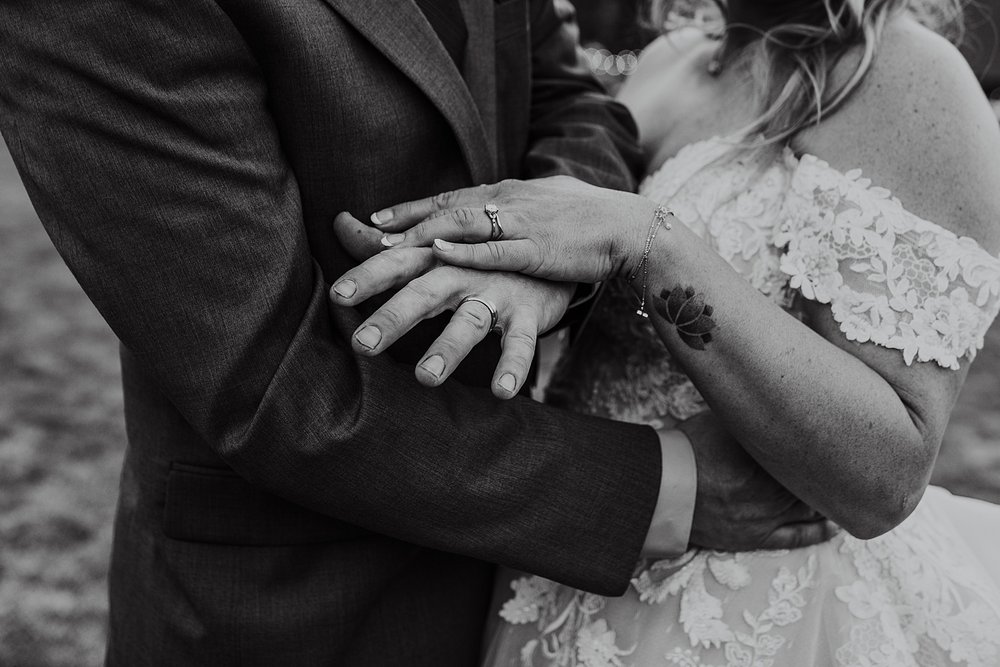 bride and grooms hands showing wedding rings, bride and groom sneaking away for sunset, peak 8 wedding reception, boreas pass wedding, breckenridge mountain wedding reception