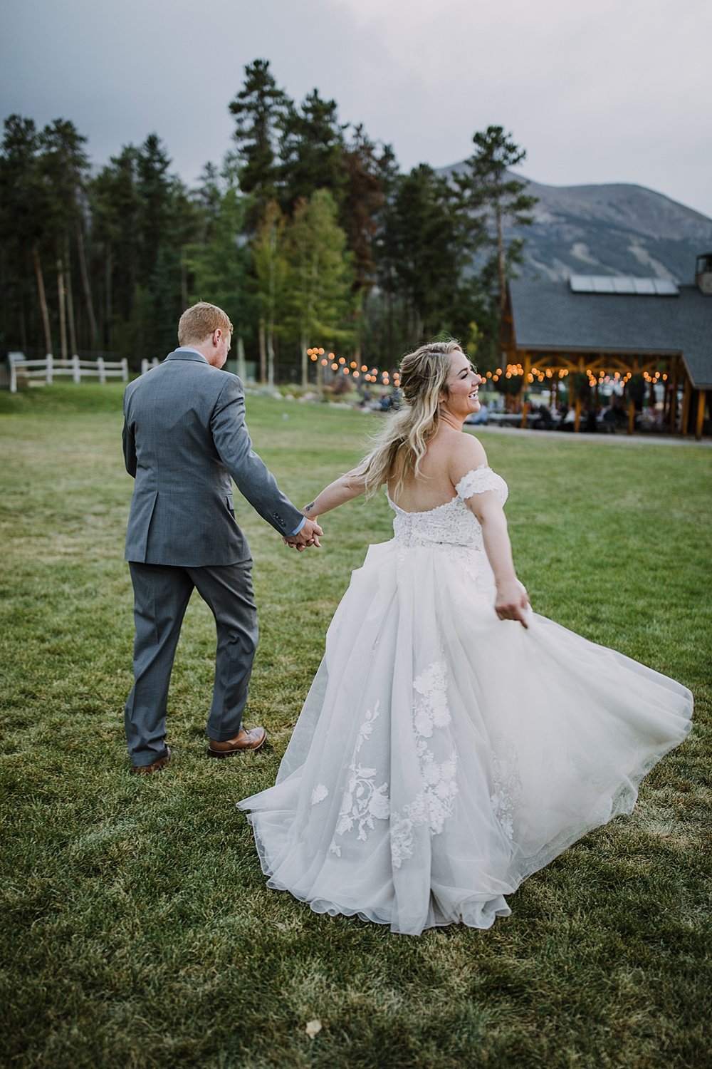 bride and groom walking on sledding hill, bride and groom sneaking away for sunset, peak 8 wedding reception, boreas pass wedding, breckenridge mountain wedding reception