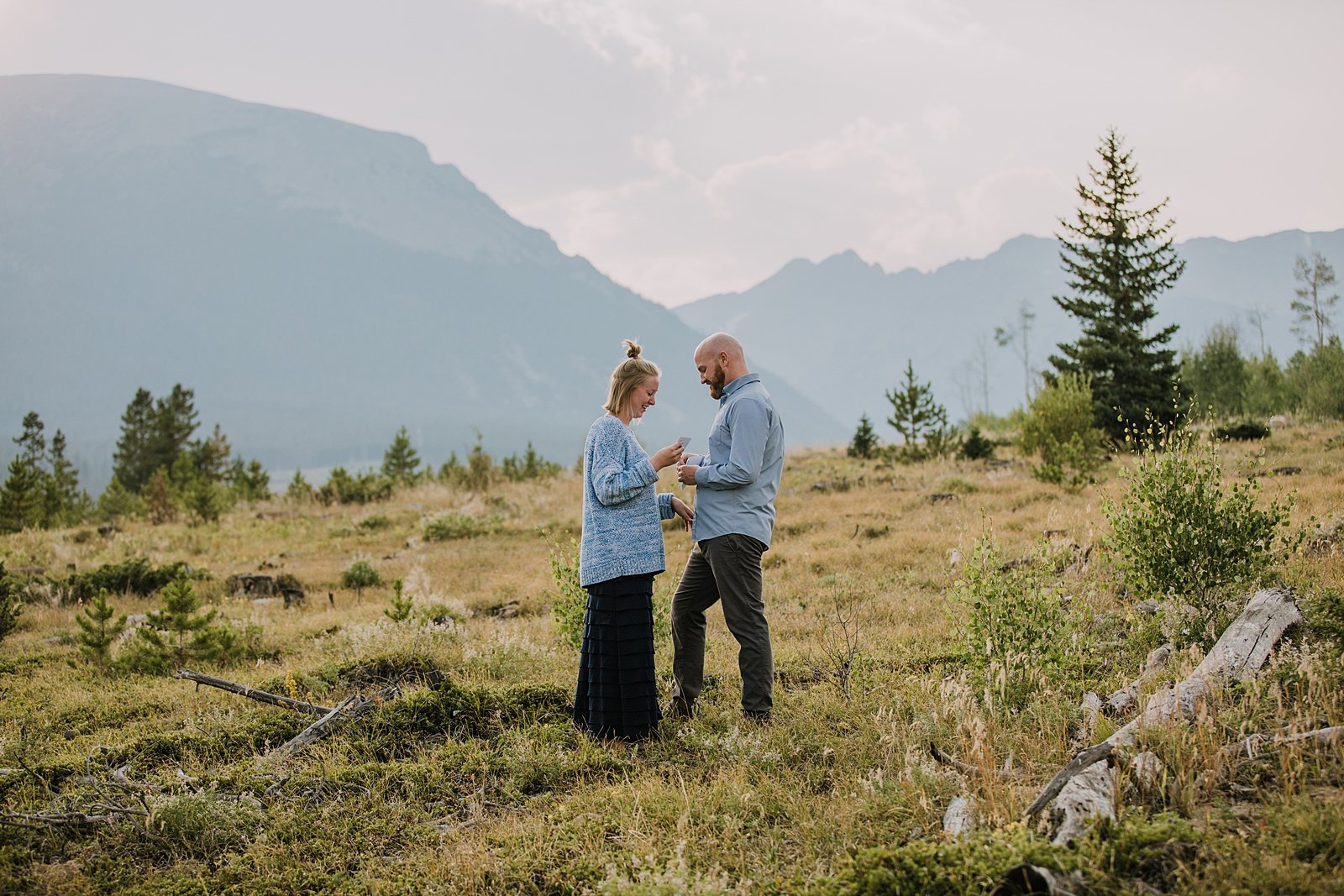 couple reading handwritten letters, postponed wedding ideas, sunset over the gore range, dillon reservoir elopement, silverthorne colorado hiking, silverthorne colorado engagement