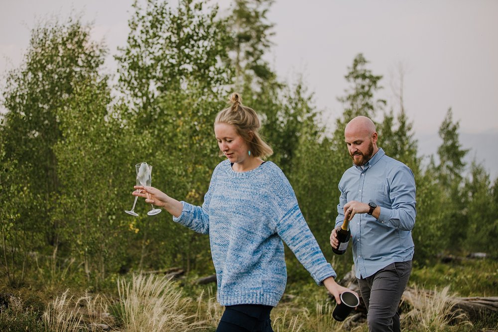 couple celebrating with champagne toast, silverthorne colorado wedding photographer, silverthorne pavilion wedding photographer, summit county wedding photographer, lily pad lake engagement