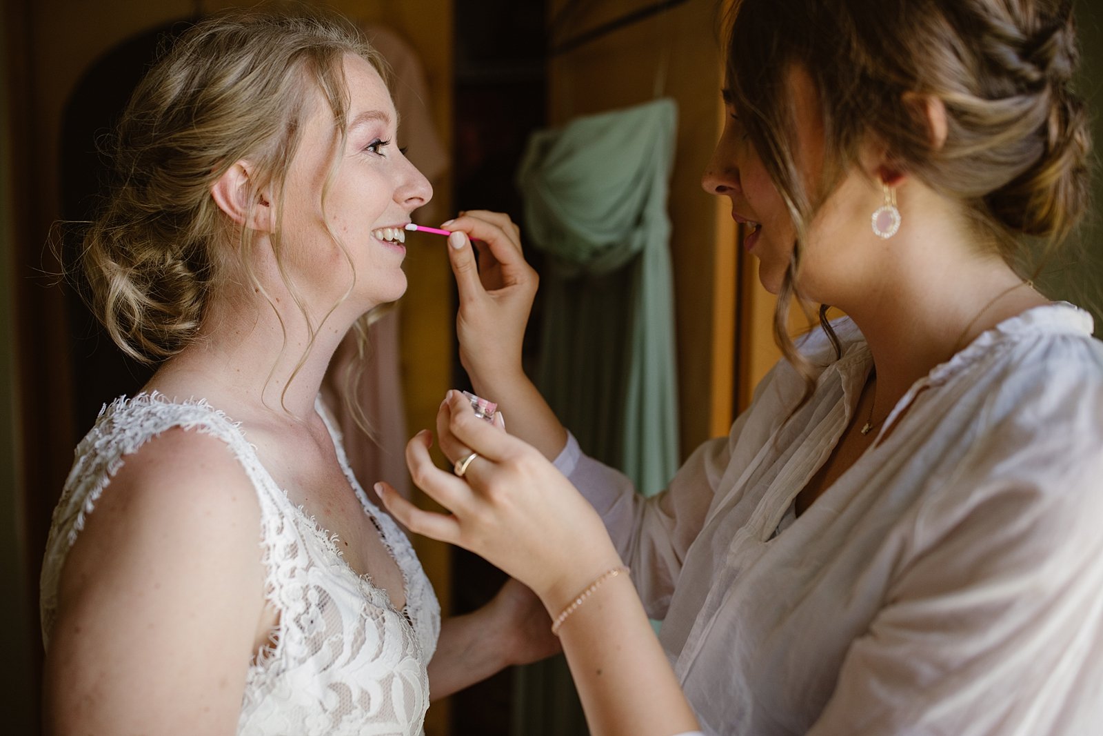 bridesmaid helping bride with makeup, bride and her bridesmaids getting ready, wedding details, mountain bridesmaids, silverthorne colorado wedding, silverthorne colorado wedding photographer