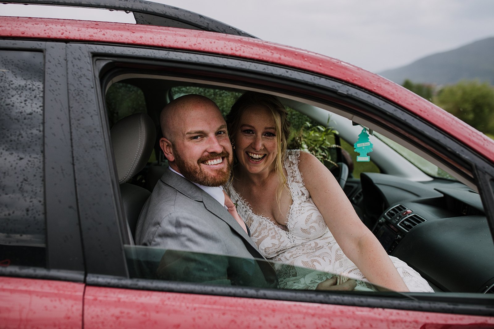bride and groom sitting in car hiding from the rain, bride and groom waiting out the rain, summit county wedding photographer, snake inlet wedding, snake inlet fishing, summit county wedding