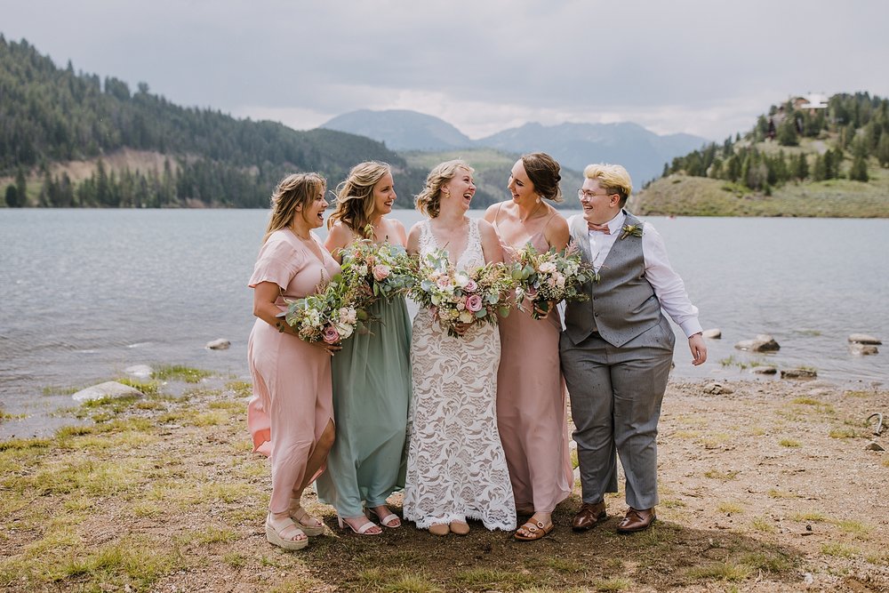 bride and bridesmaids standing together on lake shore, lake shore group photo location, summit county wedding photographer, snake inlet wedding, snake inlet fishing, summit county colorado wedding