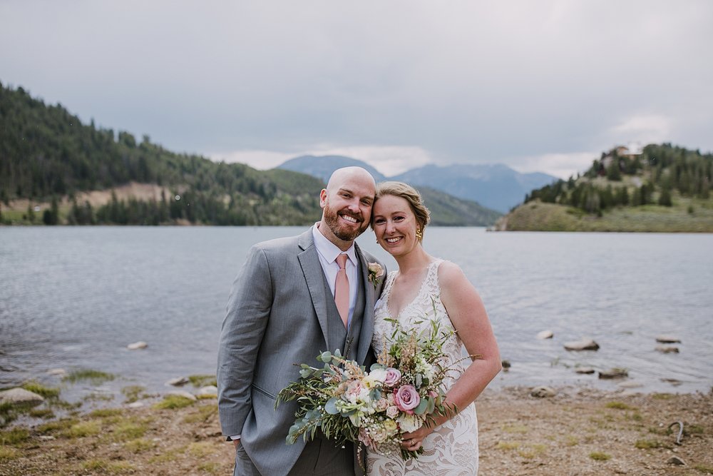 bride and groom smiling on wedding day, colorado lakeside wedding, ten mile range wedding, gore range wedding, bhldn wedding dress, gray grooms suit, ten mile range wedding photographer