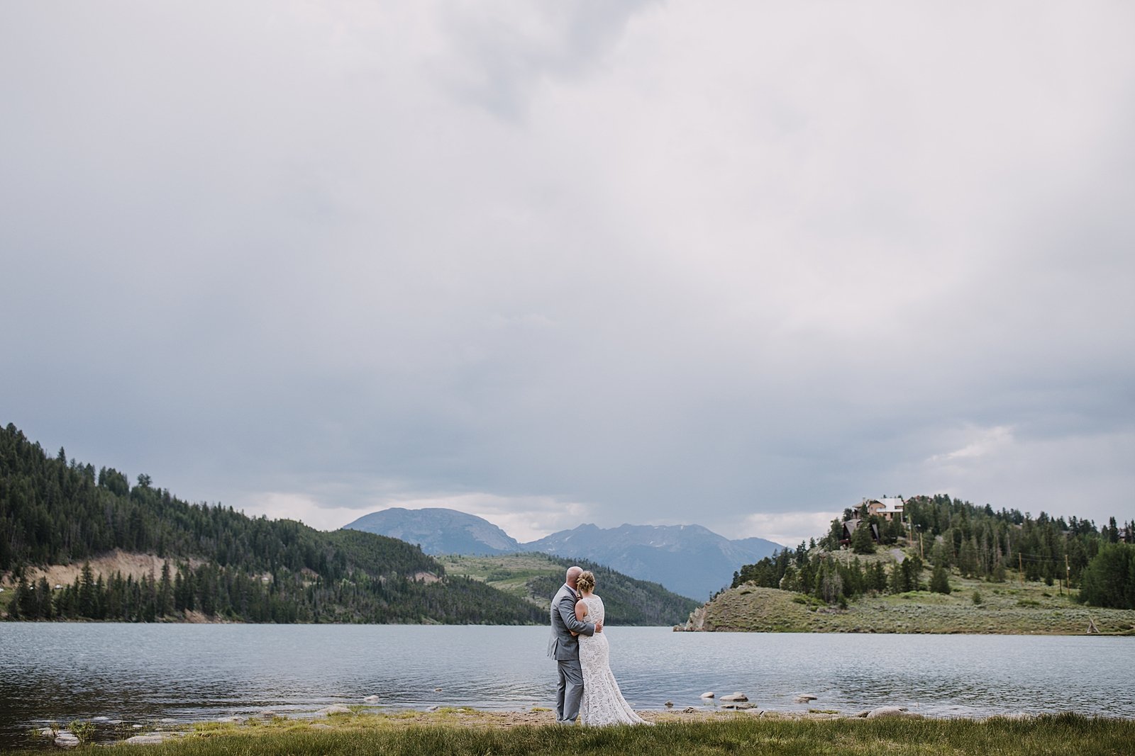 bride and groom in front of the gore range mountains, colorado lakeside wedding, ten mile range wedding, gore range wedding, bhldn wedding dress, gray grooms suit, ten mile range wedding photographer