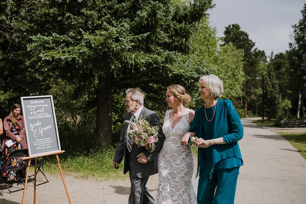 mother and father of bride walking bride down the aisle, silverthorne pavilion wedding ceremony, silverthorne colorado mountain wedding, gore range wedding, silverthorne pavilion wedding photographer