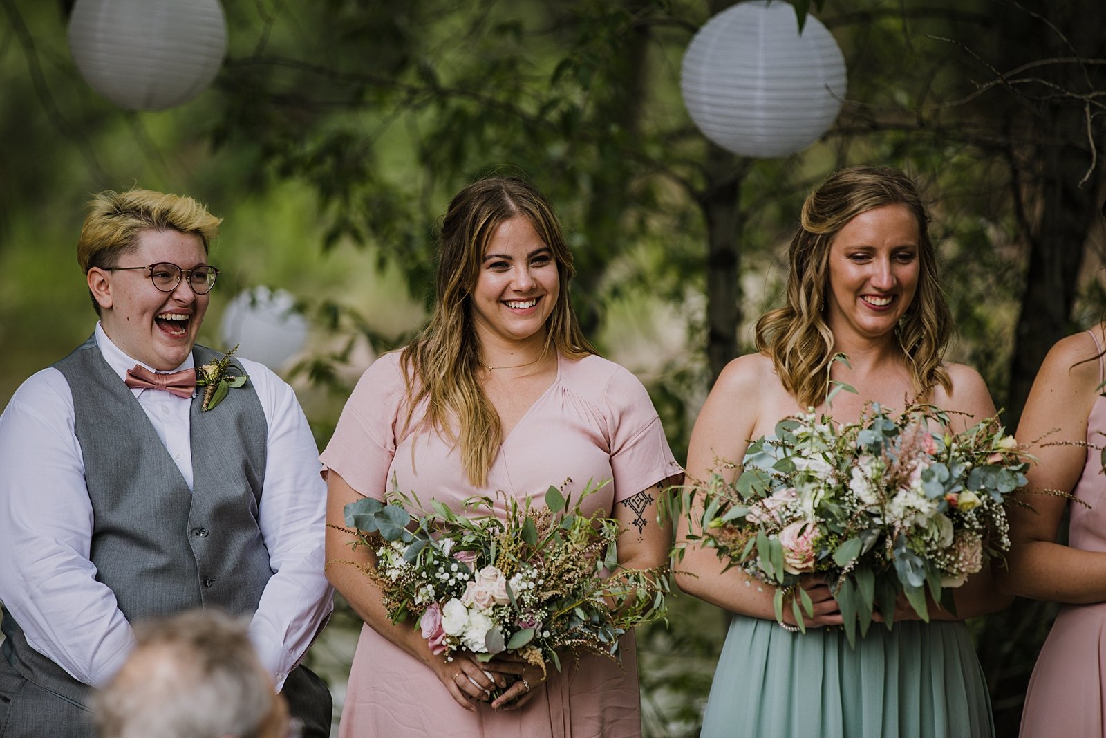 bridesmaids laughing during ceremony, wedding ceremony under trees, silverthorne colorado wedding officiant, silverthorne colorado wedding venue, riverside wedding, river bank wedding, river wedding