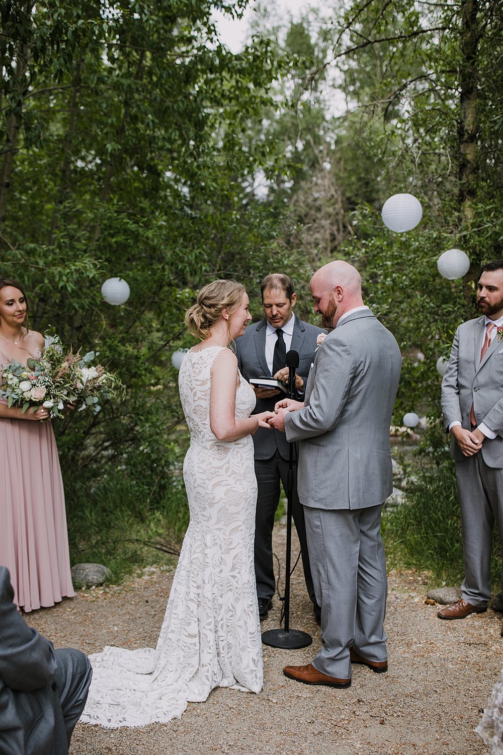 bride and groom sharing vows, wedding ceremony under trees, silverthorne colorado wedding officiant, silverthorne colorado wedding venue, riverside wedding, river bank wedding, river wedding