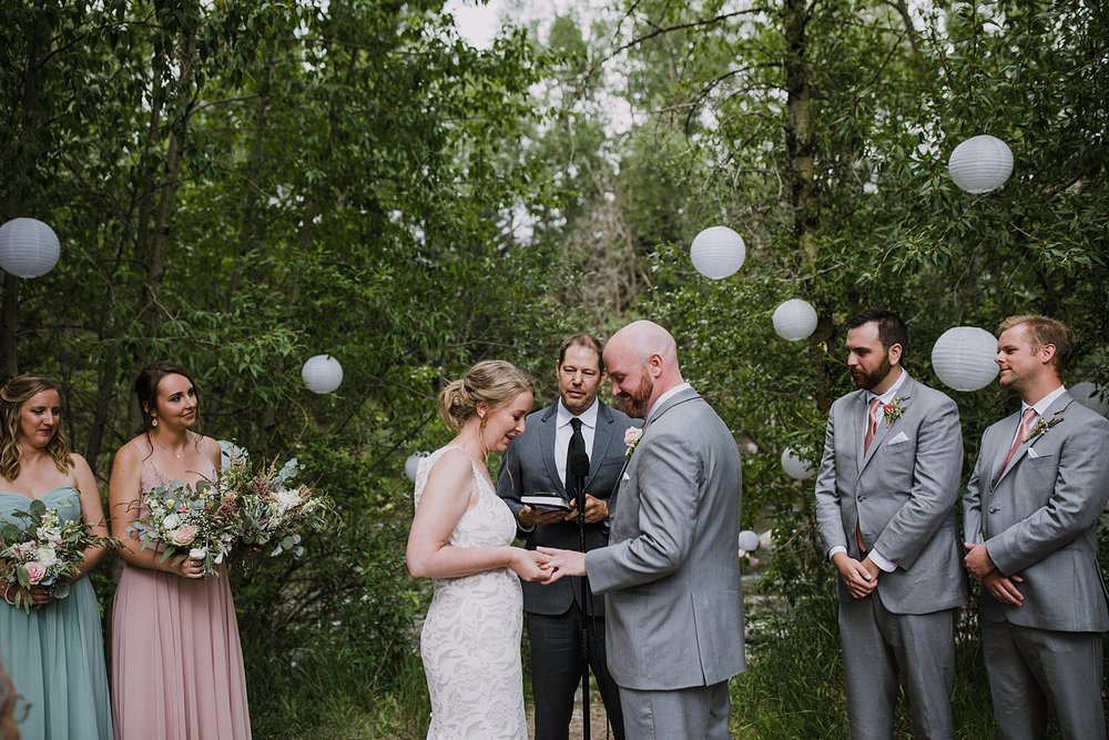 bride and groom exchanging rings, forest wedding ceremony site, summit county wedding venue, mountain forest wedding, mid summer evening wedding, summit county colorado jewelers