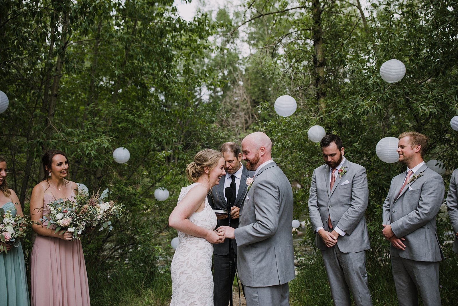 bride having to force on grooms ring, forest wedding ceremony site, summit county wedding venue, mountain forest wedding, mid summer evening wedding, summit county colorado jewelers