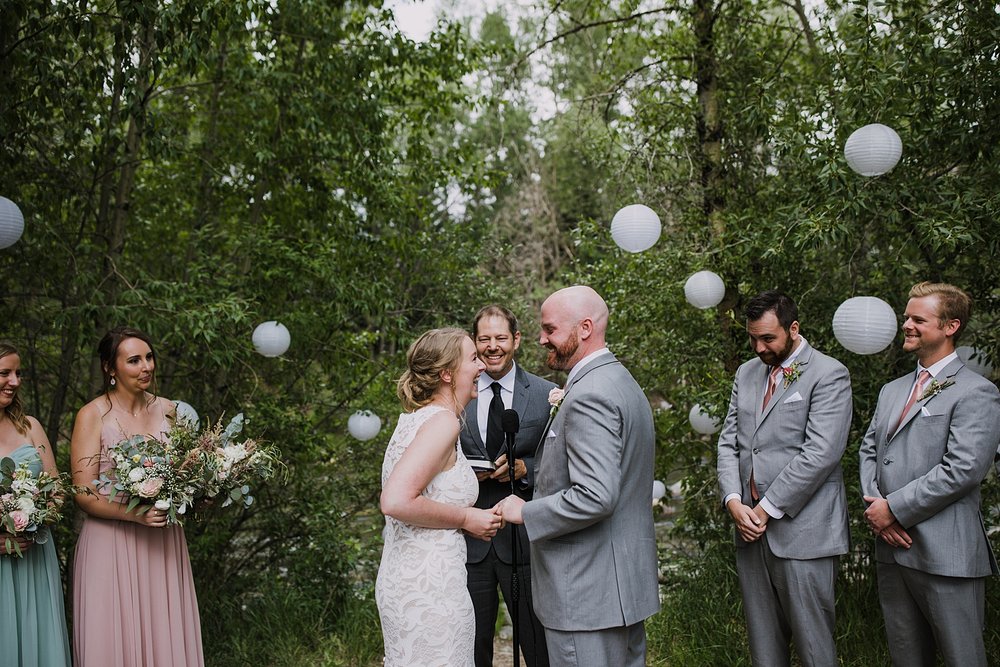 bride forcing on grooms ill fitting ring, forest wedding ceremony site, summit county wedding venue, mountain forest wedding, mid summer evening wedding, summit county colorado jewelers