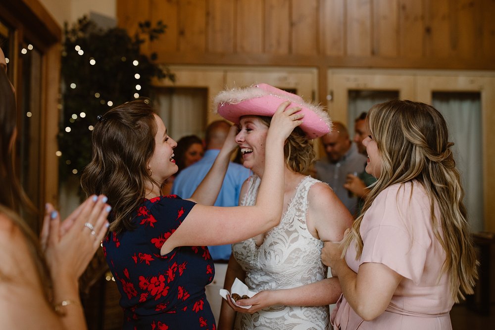 bride with cowboy hat, silverthorne pavilion bar, silverthorne pavilion wedding reception, summit county wedding patio, silverthorne pavilion cocktail hour, silverthorne colorado wedding