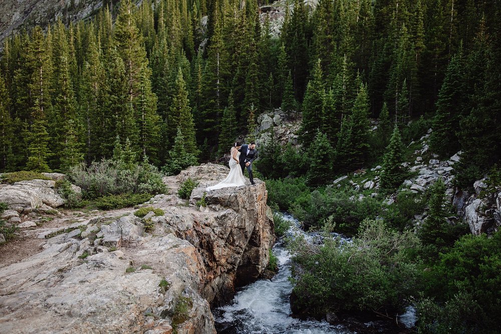 couple on a cliff looking down at the river, breckenridge waterfall, blue lakes elopement, blue lakes hike, mt quandary elopement, crystal lakes elopement, mohawk lakes elopement, cliffside elopement