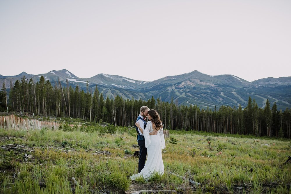 bride and groom standing in a mountain meadow with breckenridge tenmile range in the background, tenmile range elopement, breckenridge airbnb wedding, breckenridge vrbo wedding, boreas pass elopement