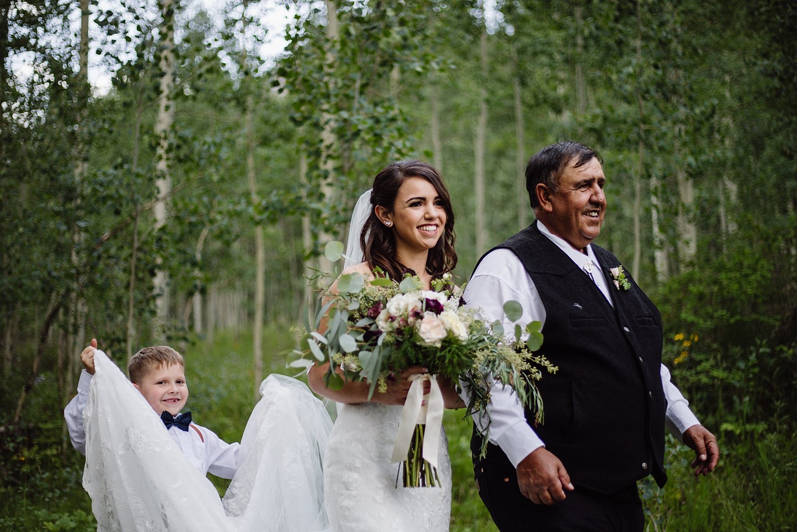 ring bearer carrying bride's train, father of the bride walking bride down the aisle, breckenridge forest wedding, breckenridge mountain resort wedding, breckenridge outdoor summer elopement