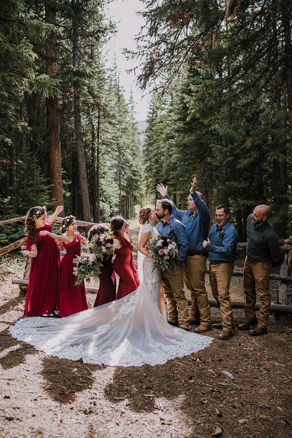 bridal party celebrating in the woods, maroon bridesmaid dress, breckenridge nordic center wedding, groom fly fishing boutonniere, breckenridge forest elopement, petal and bean wedding florals