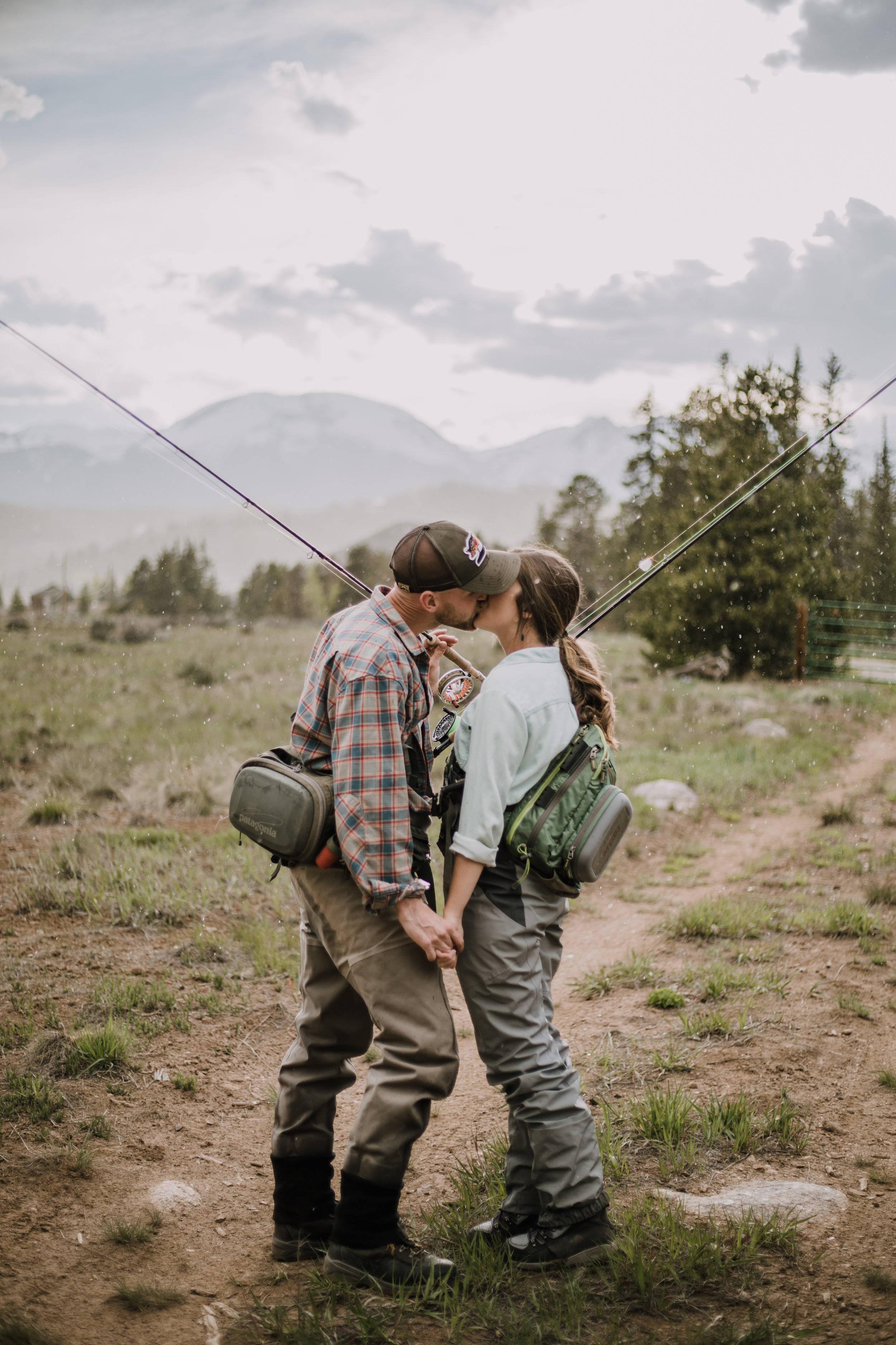 couple kissing, couple fly fishing together, breckenridge fly fishing, breckenridge fishing spots, fly fishing engagements, fishing engagements, blue river fishing, blue river fly fishing