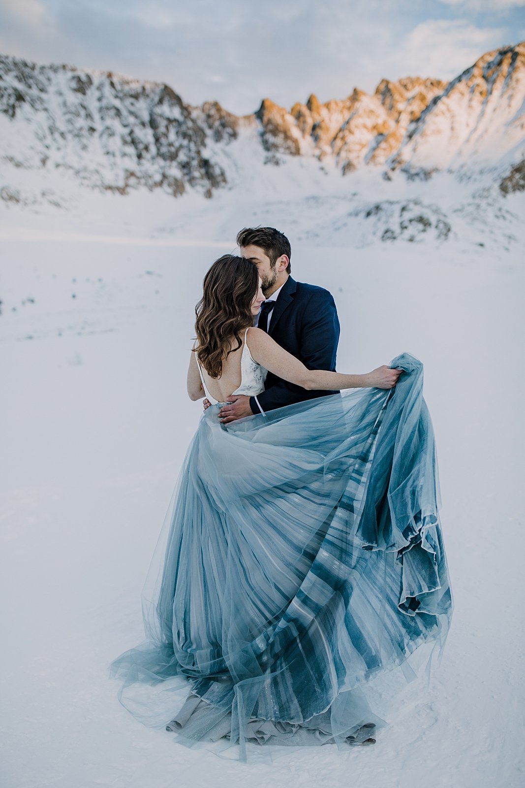 bride and groom dancing together at sunset, snowy sunset elopement, breckenridge winter elopement, snowy breckenridge elopement, snowy mountain elopement, painted wedding dress