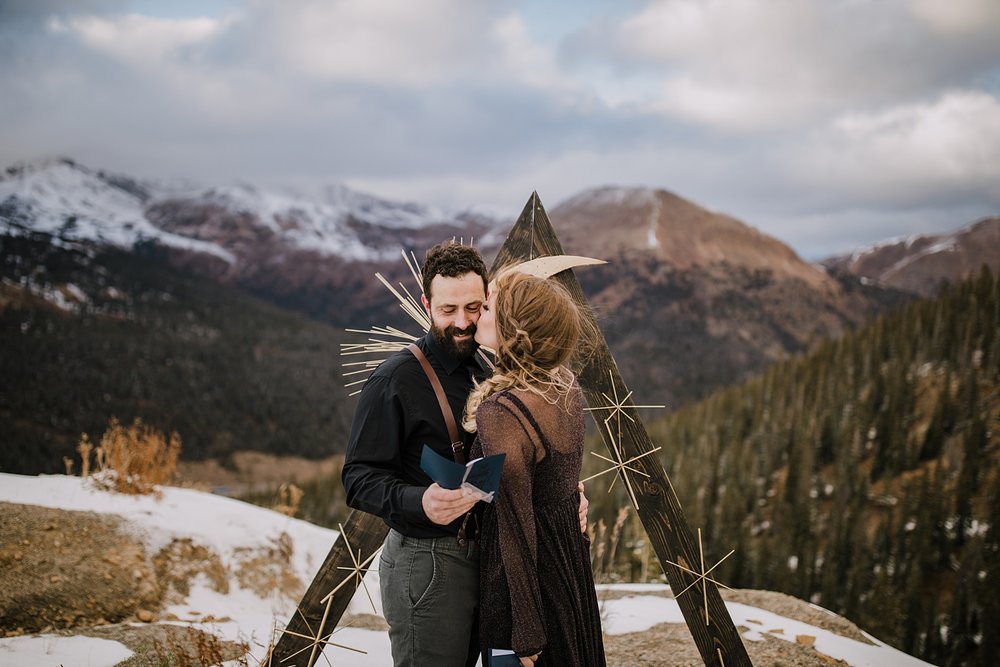 bride kissing groom on the cheek, loveland pass wedding, fall mountain elopement, fall mountain wedding, colorado fall wedding, colorado fall elopement, black wedding attire, lunar wedding theme