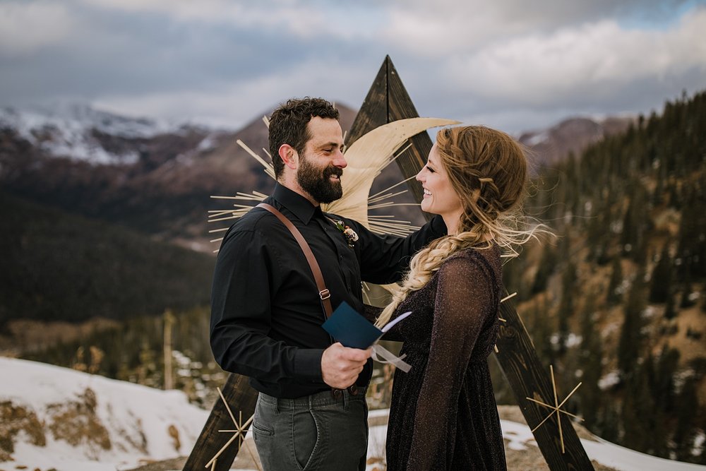 groom reading handwritten vows, celestial elopement, celestial wedding, lunar elopement, lunar wedding, black wedding dress, sparkly wedding dress, starry night themed elopement, his hers vow books