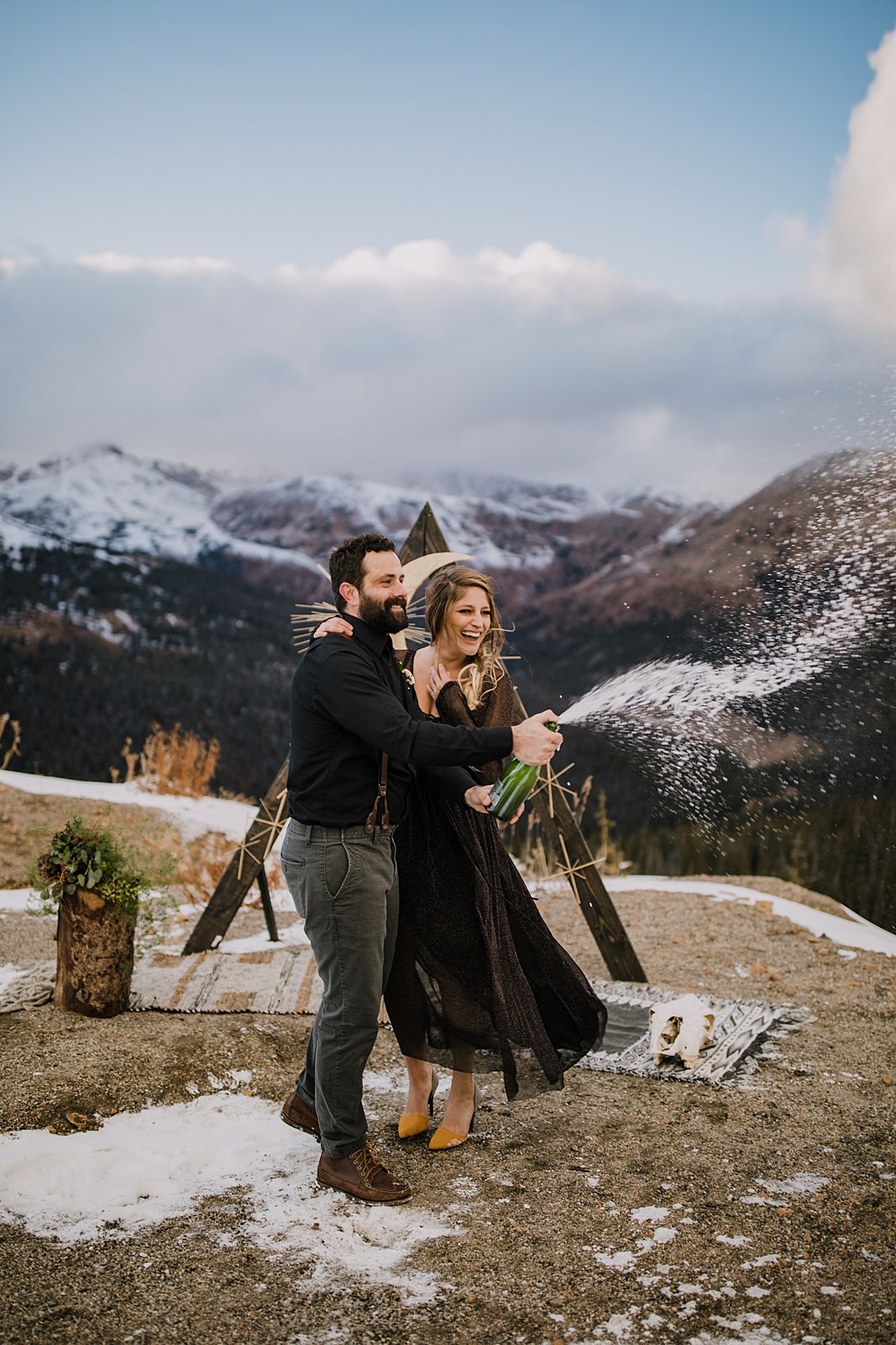 couple popping champagne, mountain top elopement, mountain top ceremony, high alpine mountain pass elopement, high alpine mountain pass wedding ceremony, mountain peak ceremony, yellow wedding heels