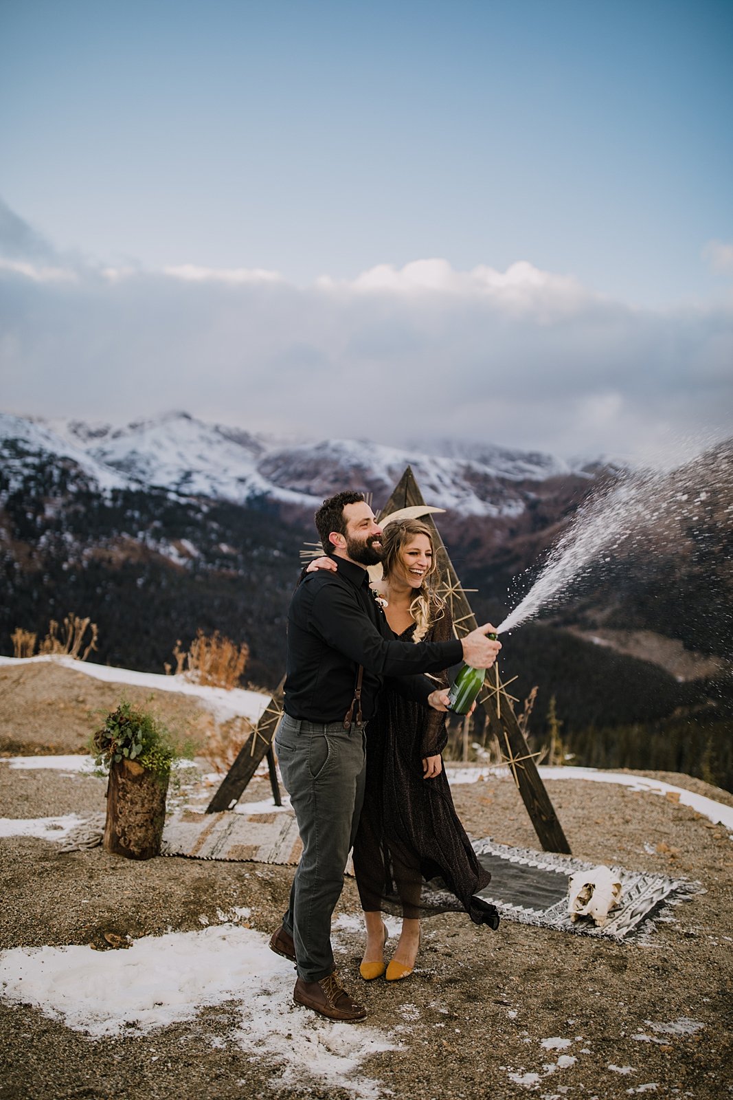 couple popping champagne, mountain top elopement, mountain top ceremony, high alpine mountain pass elopement, high alpine mountain pass wedding ceremony, mountain peak ceremony, yellow wedding shoes