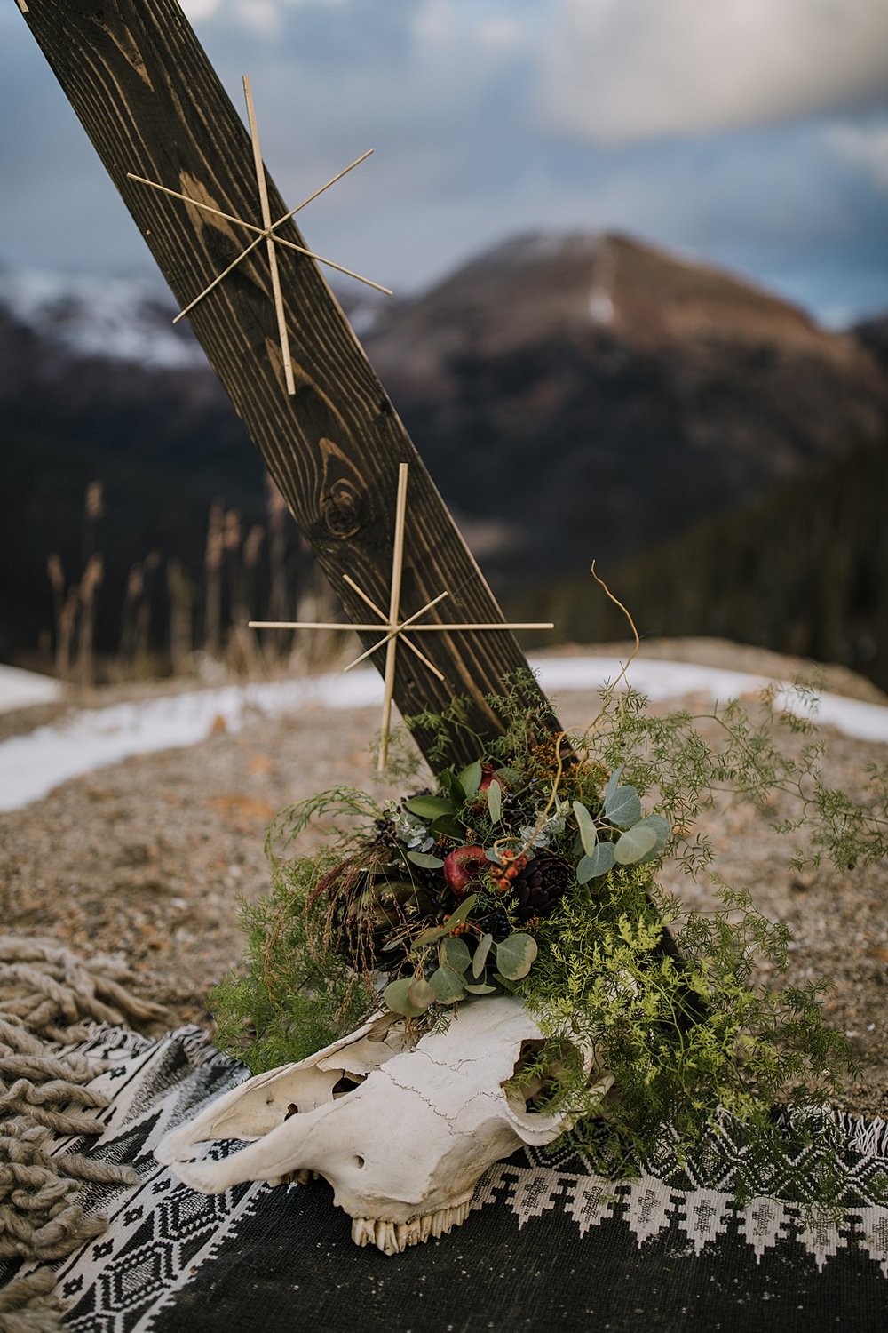 terrestrial wedding decor at the base of the arch, taxidermy wedding decorations, cattle skull wedding decor, animal skull wedding decor, florals with pomegranates, dried fruit and berry fall florals